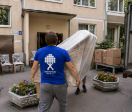 Грузчики выносят упакованную мебель при переезде
